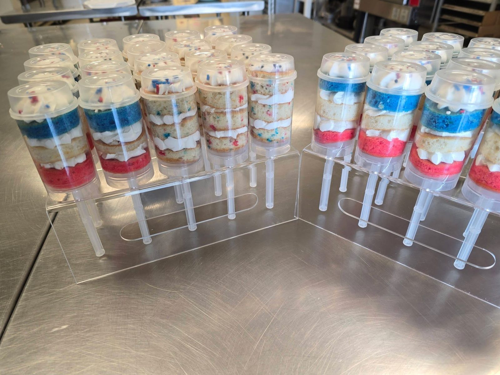 Trays of layered cake push-up cups with frosting and sprinkles