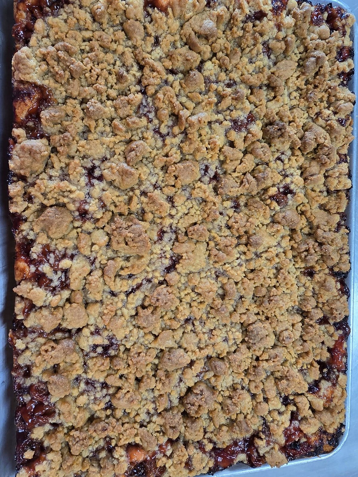 A tray of coffee cake with a thick crumb topping over fruit filling